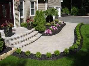 picture of a beautifully designed garden surrounding a paver walkway with newly installed bushes and flowers in seattle washington